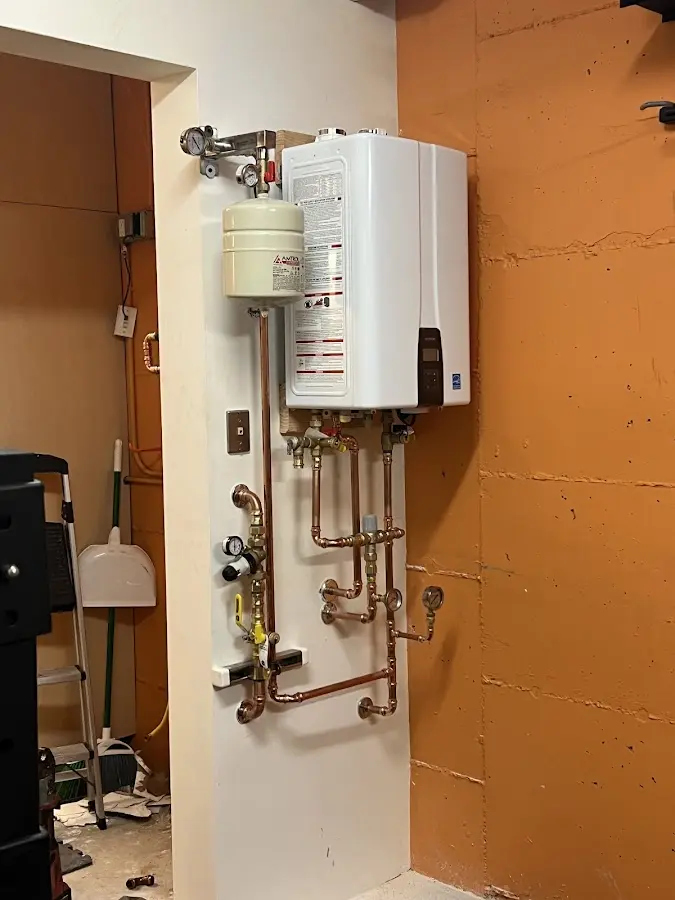 Plumbing technician inspecting water heater connections in Boynton Beach